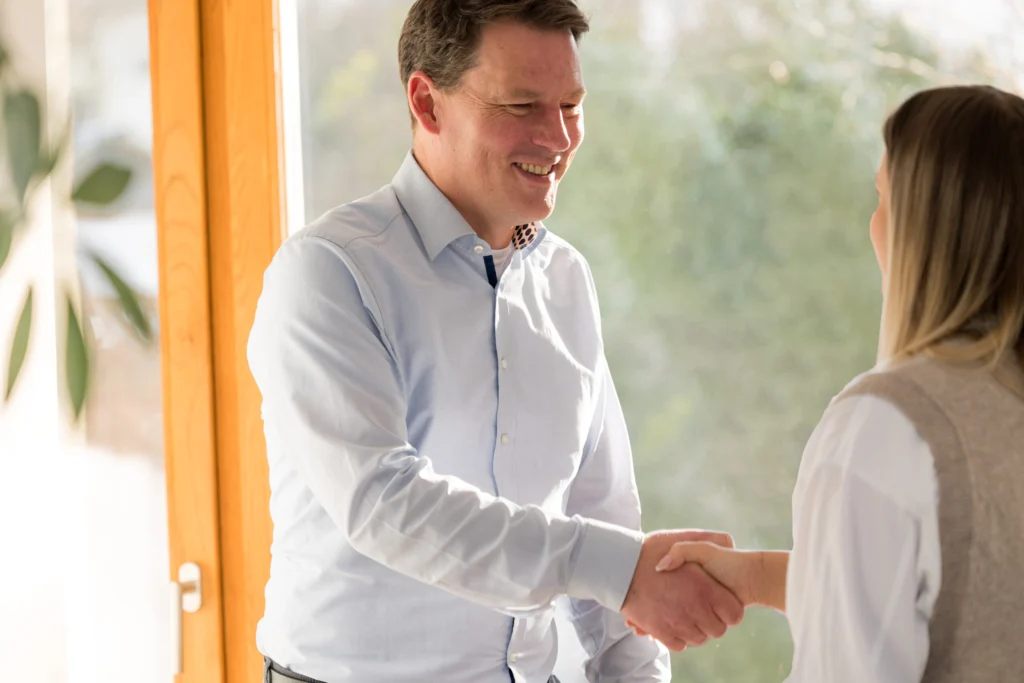 Begrüßung einer Mandantin per Handschlag bei Wittlich und Partner